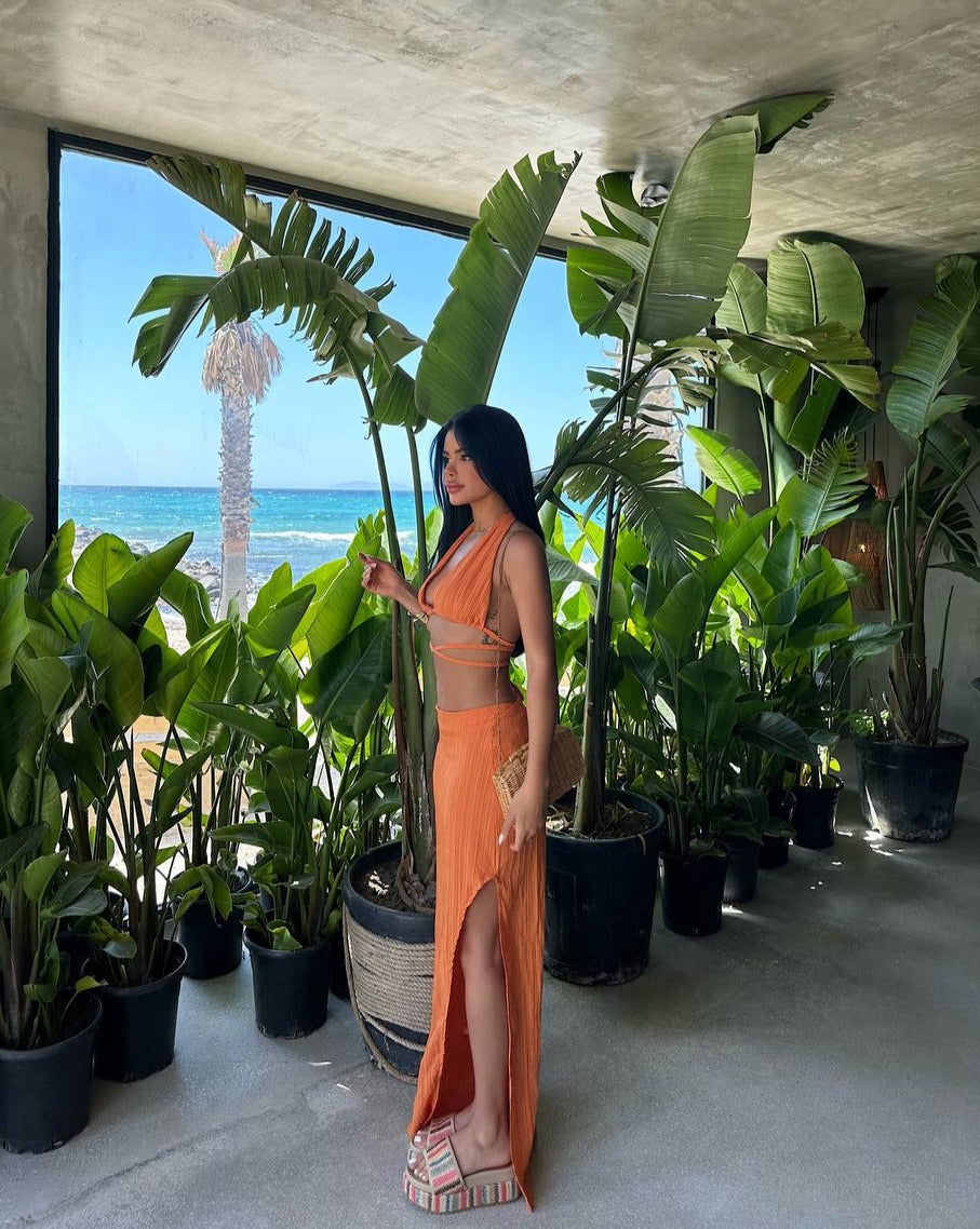 "Side view of the model in the Tropical Chic Set in orange, highlighting the fitted silhouette and bold design."