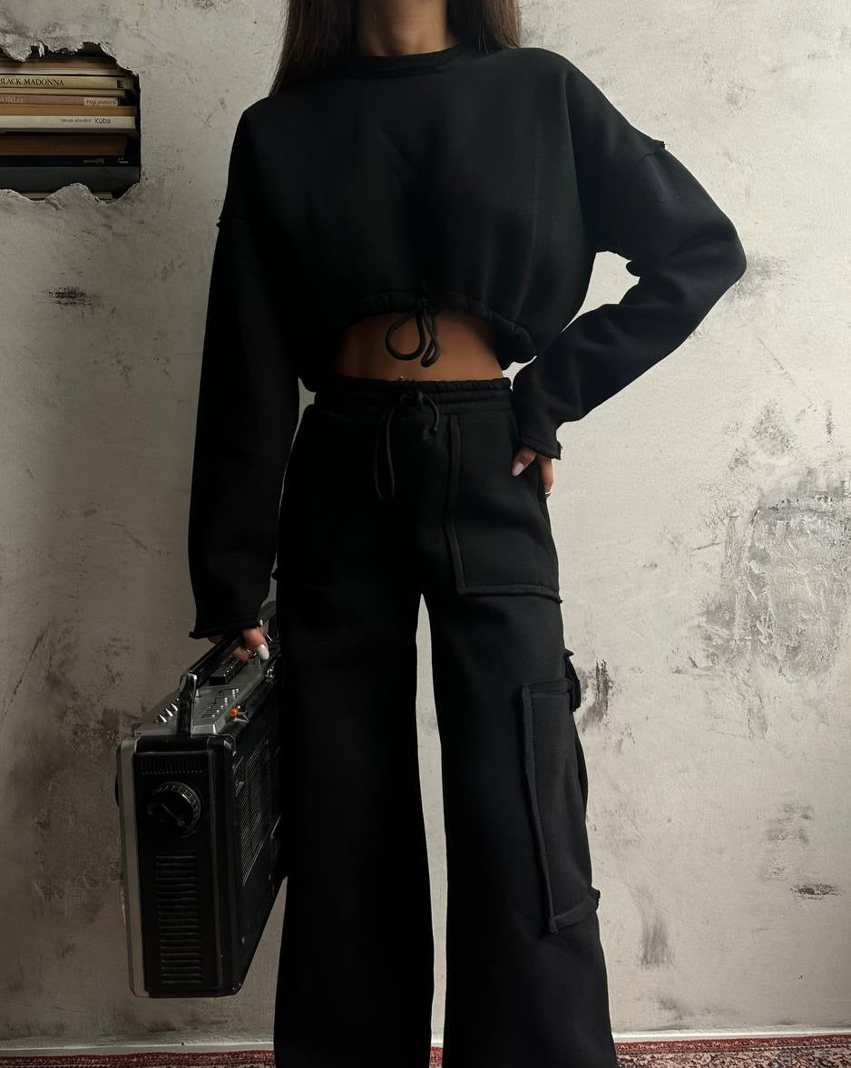 Model showcasing Amina Black Oversized Cargo Sweat Set, striking a casual pose.