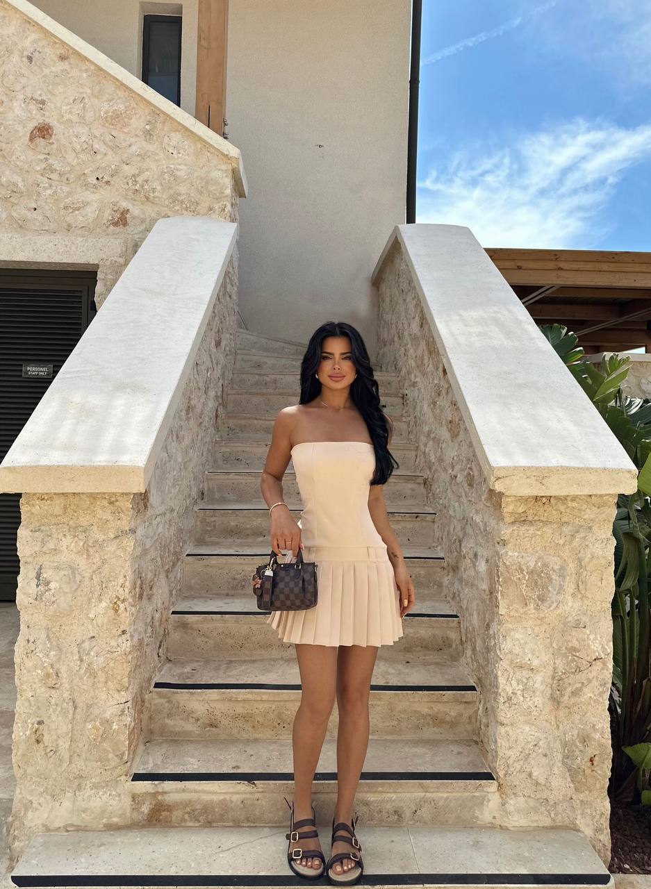 Model posing in the Milan Summer Pleated Dress with strappy sandals