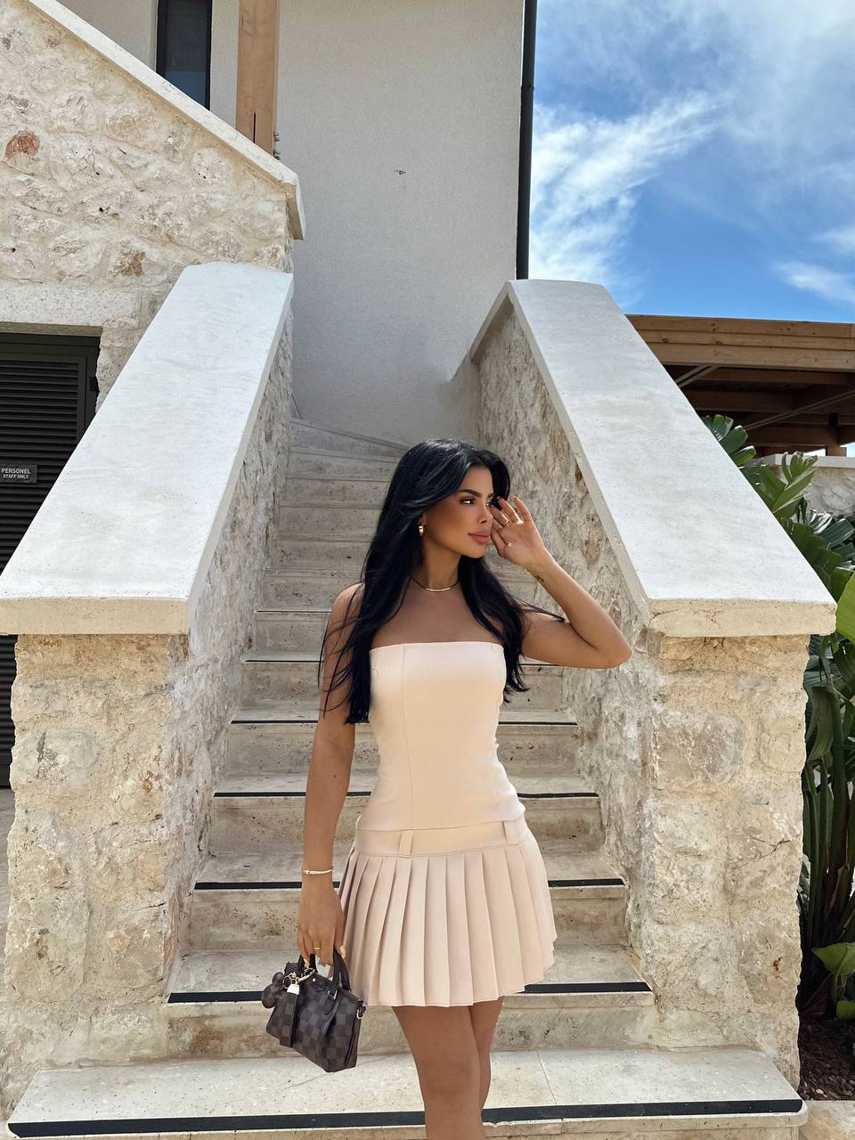 Model posing in the Milan Summer Pleated Dress with strappy sandals