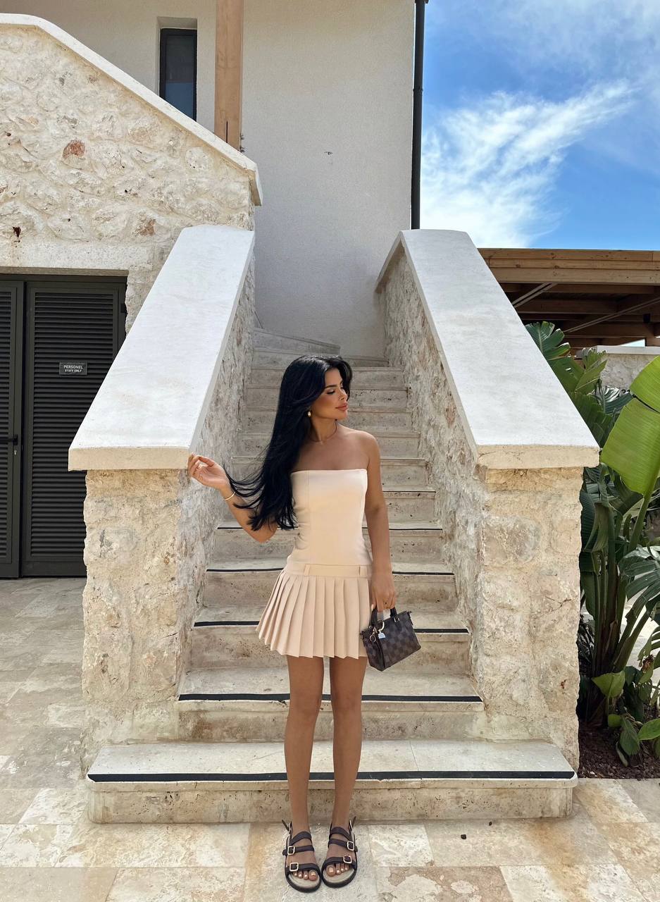 Model posing in the Milan Summer Pleated Dress with strappy sandals on a holiday