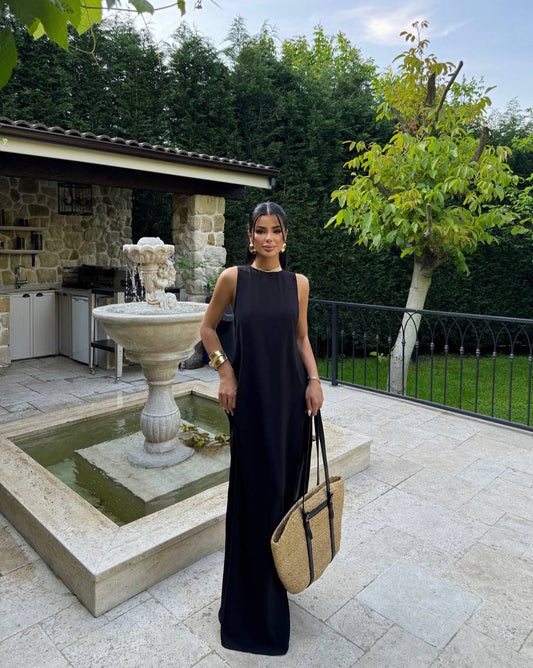 Model wearing the Santorini Breeze Maxi Dress in black by the fountain