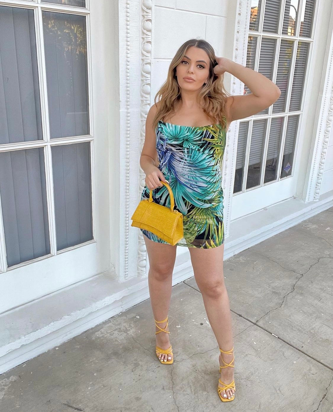 Model wearing Mutu Aruba Mesh Mini Dress with side and back cutouts, in a vibrant tropical print".
