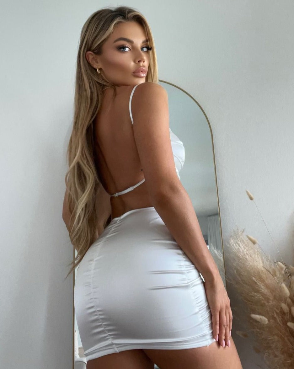 Model showcasing stylish Amara satin mini dress with open back apron design