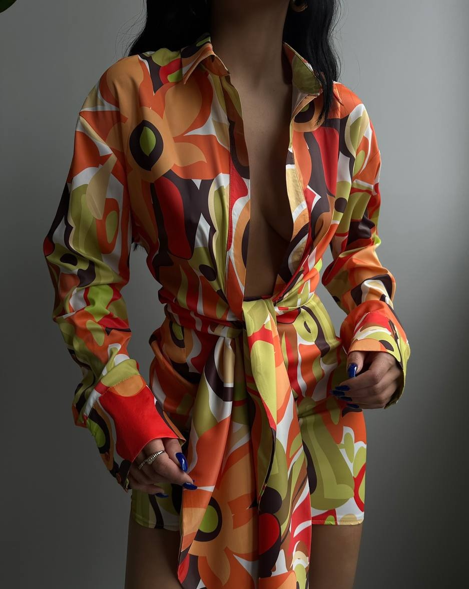 Close-up view of the bold and colorful retro floral print on the Vibrant Retro Garden Bound Mini Dress