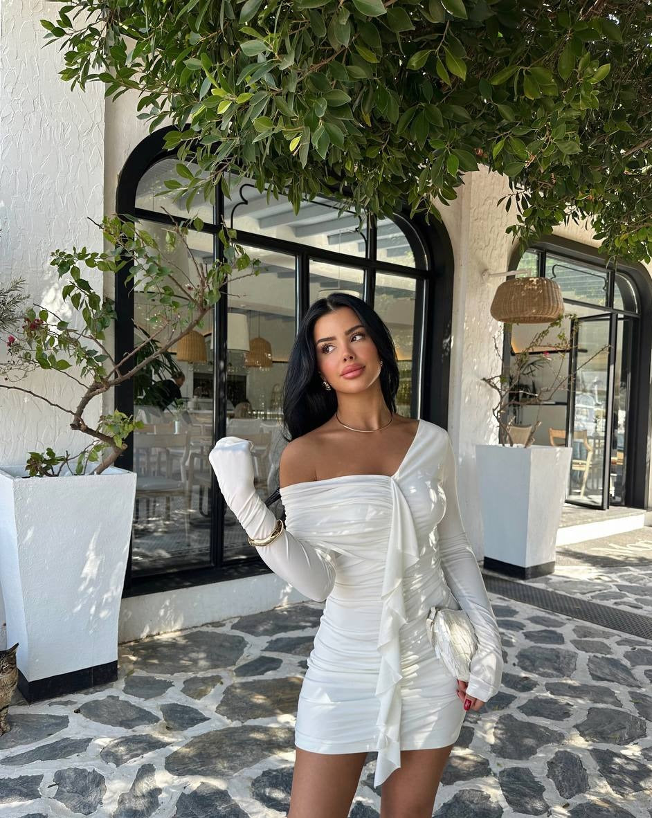 "Close-up of a white ruffle detail mini dress on a model, highlighting the dress's sandy fabric texture and delicate ruffle accents. The dress is size S, with a length of 60 cm and a bust measurement of 35 cm."