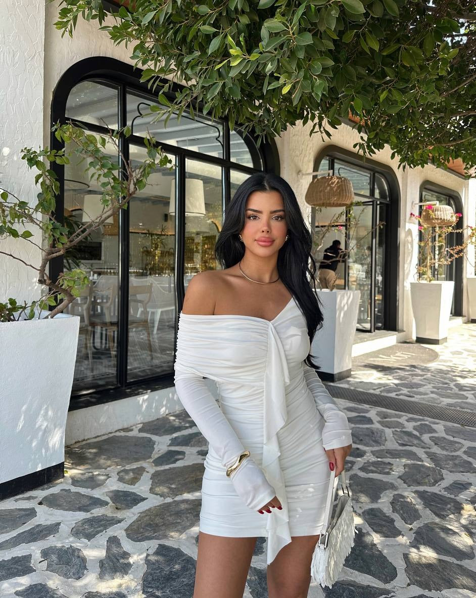 Close-up view of the White Ruffle Detail Mini Dress in sandy fabric, worn by a model. The mini dress has a ruffle detail, with a length of 60 cm and a bust measurement of 35 cm. Model details: 160 cm tall, weighs 50 kg, with an 80 cm chest, 62 cm waist, and 94 cm hips."