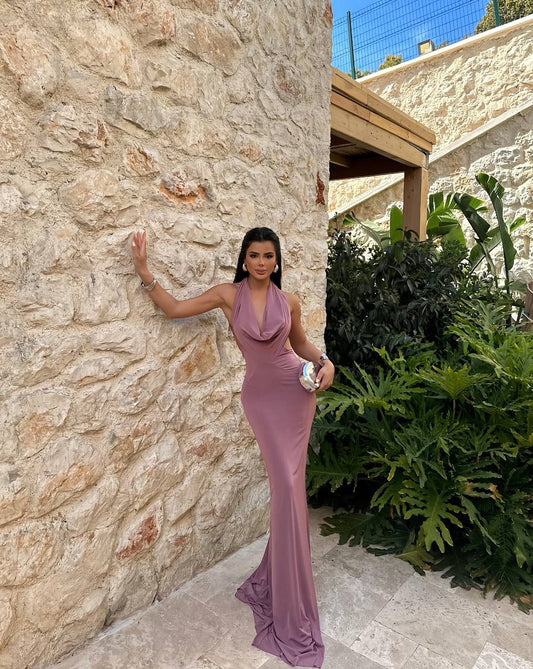 Model wearing Dusty Rose Pamella Backless Long Dress against a stone wall