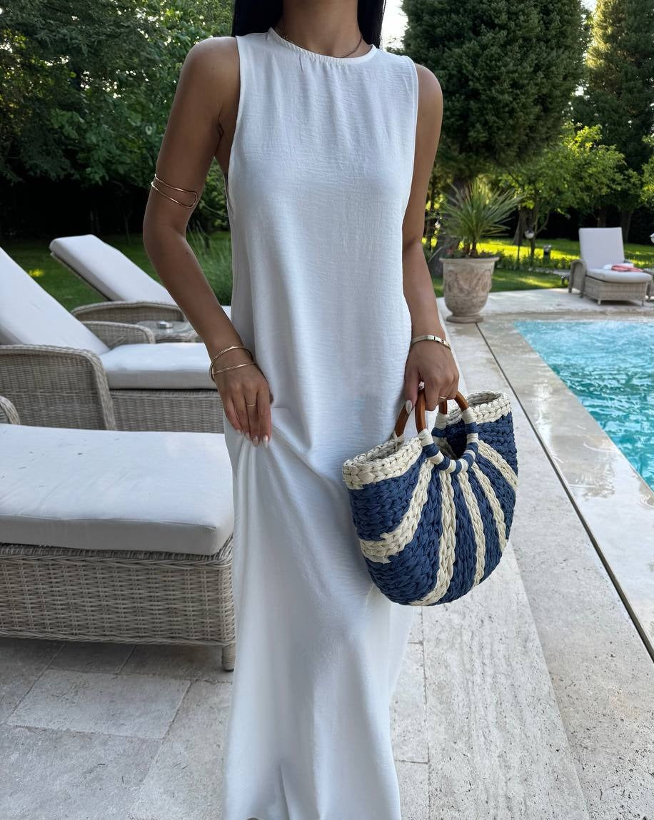 Model wearing the Santorini Breeze Maxi Dress in white by the poolside