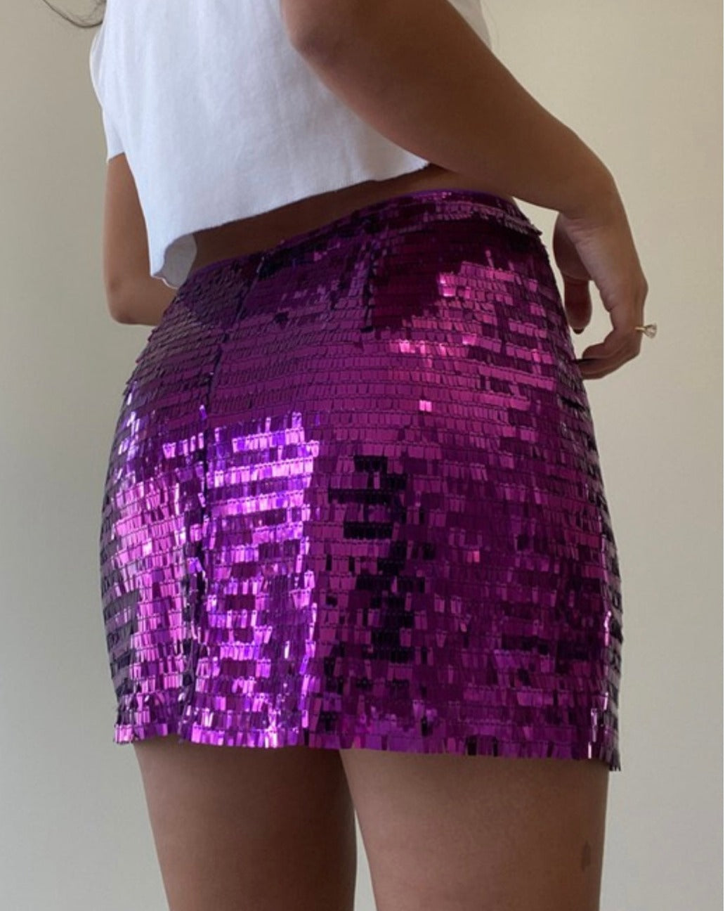 Model showing off the low waist design of the grape Kimmy Sequin Mini Skirt