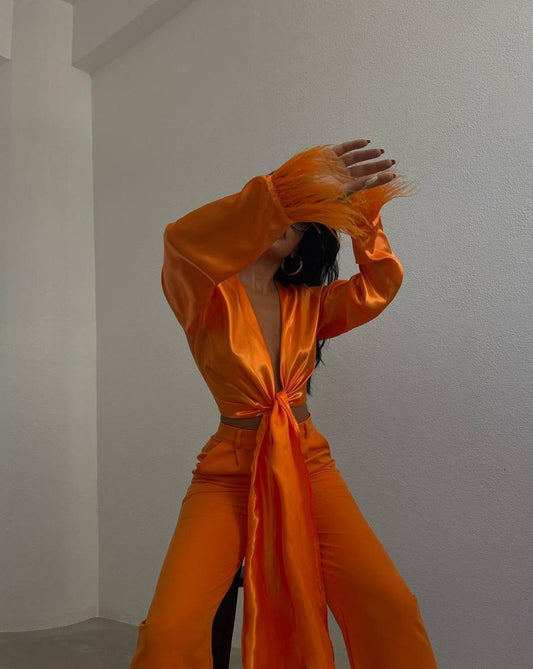 Model wearing vibrant Ferlayne Orange Feather-Embellished Crop Top with self-tie front detail
